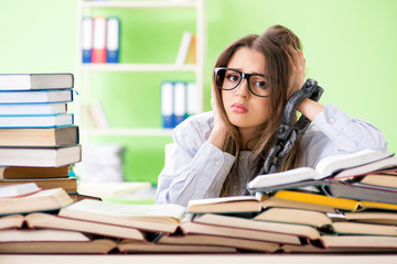 Young female student chained to the desk and preparing for exams