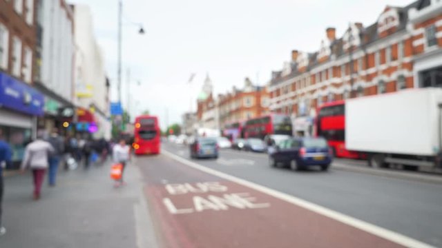 Out of focus shot of pedestrians and traffic on urban street in Brixton, London 