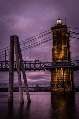 Purple tinted bridge crossing calm river