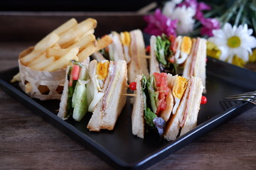 club sandwich with french fries on wooden table 