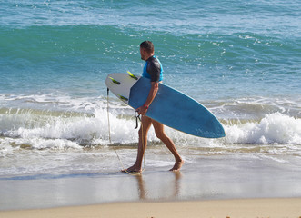 surfer walking on beach
