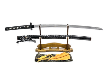 Japanese sword with shiny black dragon scabbard  on wooden stand and silk bag in the front isolated...