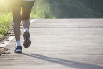 Runner woman  running on the Concrete road morning with nature of mountain and tree.
