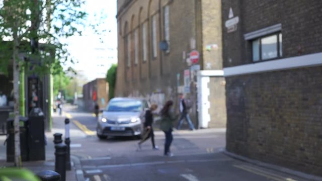 Out of focus shot of street scene in Bethnal Green area, graffiti tagged on wall