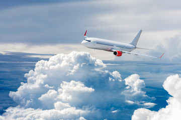Obraz premium Biały samolot lecący nad chmurą