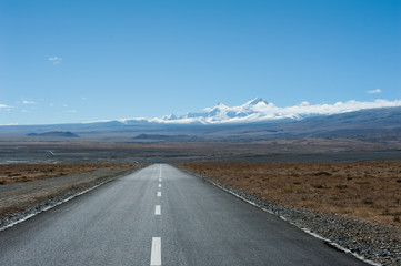 Road leading toward snow mountain peak in the distance