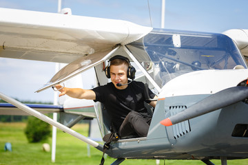 outdoor shot of young man in small plane cockpit