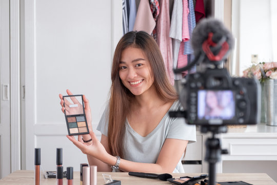 Asian young female blogger recording vlog video with makeup cosmetic at home online influencer on social media concept.live streaming viral.