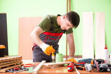 Young man carpenter working in workshop 