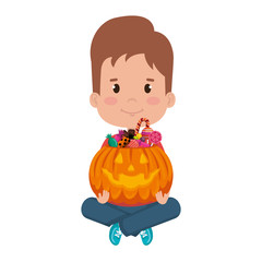 little boy lifting halloween pumpkin with candies