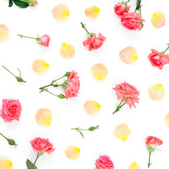 Floral pattern made of red roses flowers and orange rose petals on white background. Flat lay, top view.