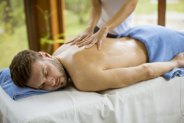 Obraz na płótnie Canvas Young man having massage in the spa