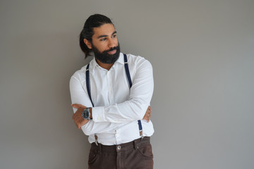 Hipster man with suspenders standing on background, isolated