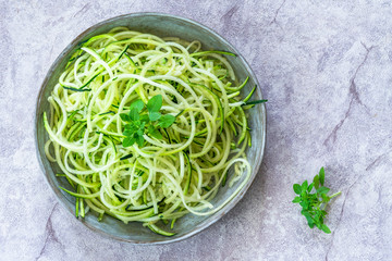 Courgette spaghetti - shredded zucchini on a plate - top view