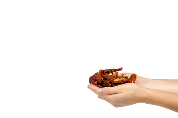 Sun dried red tomatoes with hand isolated on white background, copy space template