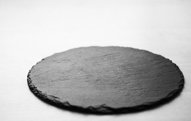 Black slate plate for food in cafe. Empty stone dish with space for product placement