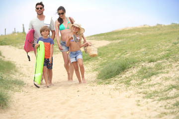 Family walking to the beach, sand dune path