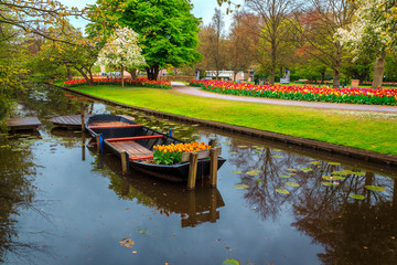 Obraz premium Ornamental boat and colorful fresh tulips in Keukenhof park, Netherlands