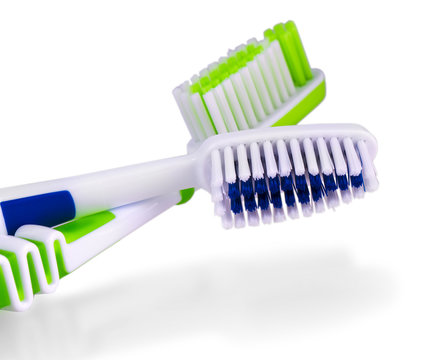 Two toothbrushes over white background