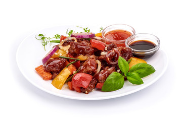Roast Sweet and Sour Pork with vegetables in a plate with sauces, Chinese recipes WOK. Isolated on white background