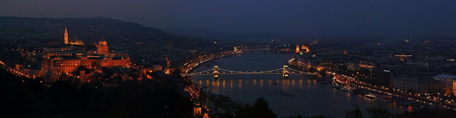 Obraz premium Panorámica del atardecer en Budapest con el río Danubio como tema central.