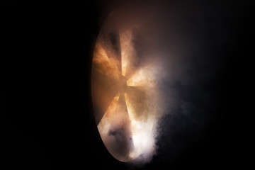 Big industrial fan in a puff of smoke. on a black background. ecology, air emissions.