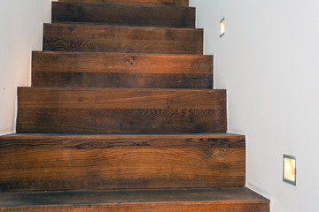 Wood stairs by night with led light in the white wall modern design