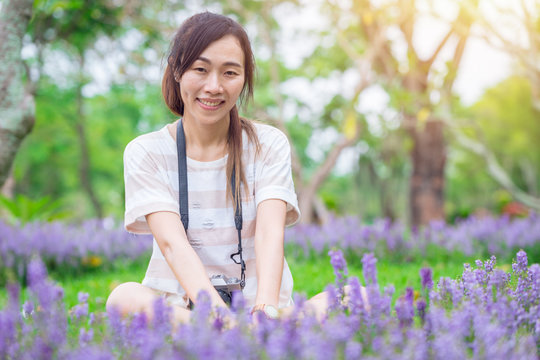 asian girl relax enjoy holiday with photography flower hobby in the park