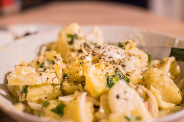Close up of a potato salad with mayonnaise, onion, parsley and oregano