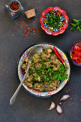 Sauteed eggplant. Salad of baked eggplants on a dark background.