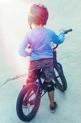 child standing with his bicycle