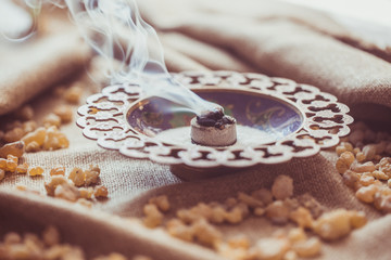 Frankincense burning on a hot coal. Frankincense is an aromatic resin, used for religious rites,...