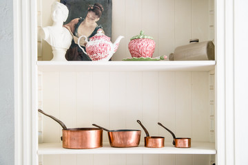 Copper kitchen saucepans standing at the counter