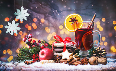 Christmas mulled red wine with spices and fruits on a wooden rustic table