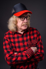 Senior man with mustache against gray background