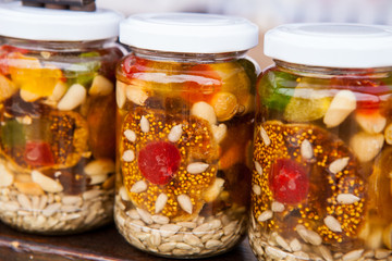 Healthy combination of natural honey with various nuts and dried fruits in jars