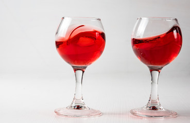 Two glasses with red juice, wine with different splashes