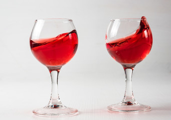 Two glasses with red juice, wine with different splashes