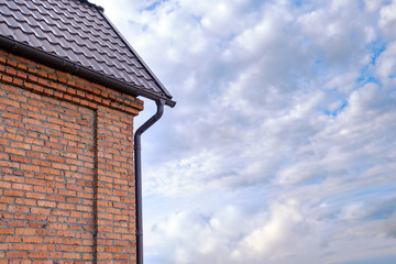 Part of a house with metal roof, wall and rain gutter
