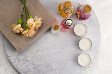 spa set, bottles , candles and flowers top view marble background  copy space