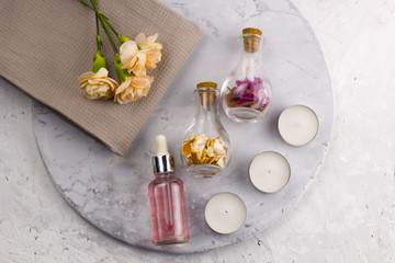 spa set, bottles , candles and flowers top view marble background