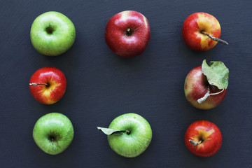 Apples on dark background, frame from ripe apples. Green and red apples