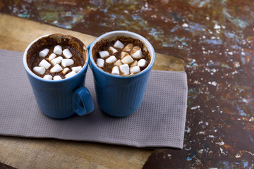 hot warming chocolate with marshmallows on wooden table served on cloth copy space