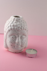 white ceramic figurine Buddha head  pink  background