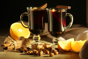 Two cups with ready mulled wine with anise, cinnamon and nuts around
