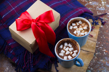 hot drink with marshmallows,plaid  and gift box with red satin ribbon top view cozy holiday