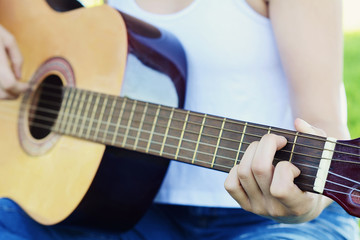 Woman playing guitar at the park.