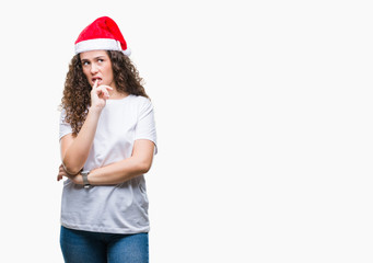 Young brunette girl wearing christmas hat over isolated background looking stressed and nervous with hands on mouth biting nails. Anxiety problem.