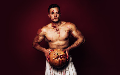Muscular Vampire butcher man with blood. Man with serious face and naked torso on red background....
