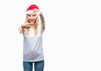 Young beautiful blonde woman christmas hat over isolated background smiling making frame with hands and fingers with happy face. Creativity and photography concept.